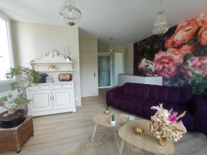 salon z fioletową kanapą i stołami w obiekcie Appart proche centre- gare-stade-hôpital- Prisme-Belle vue w mieście Aurillac