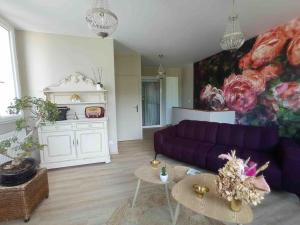 salon z fioletową kanapą i obrazem w obiekcie Appart proche centre- gare-stade-hôpital- Prisme-Belle vue w mieście Aurillac