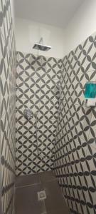 a bathroom with a shower with black and white tile at Venere Home in Ponte Galeria