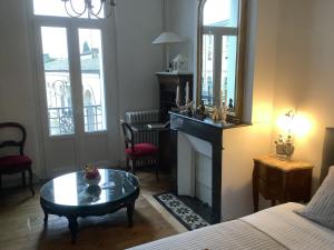 a room with a bed and a table and a mirror at Chambre privée Marmande centre ville in Coye-la-Forêt