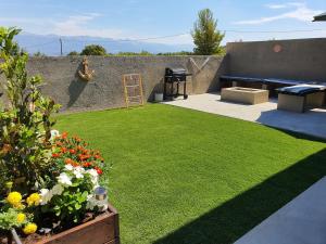 un jardin avec une pelouse artificielle et un mur dans l'établissement La Dolce Vita Apartment, à Posedarje