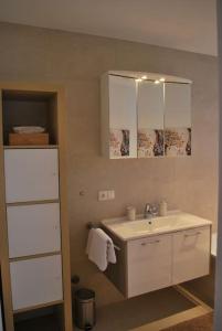 a bathroom with a sink and a towel rack at Wohnung direkt am Tegernsee mit XL-Terrasse in Gmund am Tegernsee