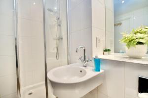 a white bathroom with a sink and a shower at City Loft Apartment in Coventry