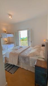 ein Schlafzimmer mit einem großen Bett und einem Fenster in der Unterkunft Villa Coração in Monte Verde