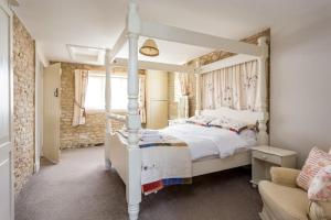 a bedroom with a white canopy bed and a couch at Stanton House, 6 bedroom, 5 bath in Cheltenham