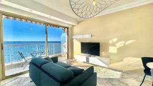 Sala de estar con sofá azul y vistas al océano en « LA SUITE »Superbe appartement NEUF, Front de mer, en Menton