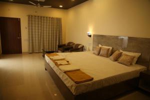a bedroom with a large bed in a room at Ashoka Lawns and Resort in Alibaug