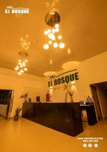 um hall de entrada com um sinal de patrão na parede e luzes em Hotel El Bosque em Xaém