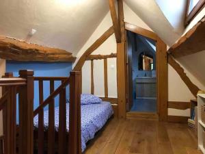 sypialnia z łóżkiem i drewnianymi schodami w obiekcie La Laiterie Normande 