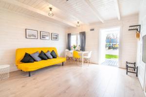 a living room with a yellow couch and a table at MAXCAMP w Dziwnowie in Dziwnów