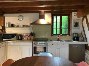 cocina con mesa de madera en La Laiterie Normande, 