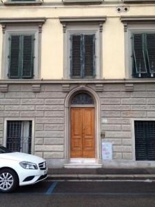 a white car parked in front of a building with a wooden door at Appartamento Cosimo in Florence