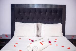 uma cama com uma cabeceira preta e rosas em WhiteHouse Lodge em Harare