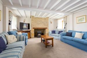 a living room with blue couches and a fireplace at Broadway House, 7 Bedroom, 6 Baths in Cheltenham