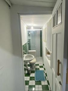 y baño con aseo y lavamanos. en Suítes no Centro Histórico de Paraty en Paraty