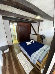 Un dormitorio con una cama azul con toallas. en Suítes no Centro Histórico de Paraty, en Paraty