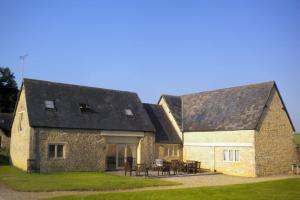 an old stone building with a table and chairs at Broadway House, 7 Bedroom, 6 Baths in Cheltenham