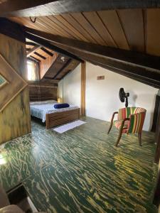 1 dormitorio con 1 cama y 1 silla en Suítes no Centro Histórico de Paraty, en Paraty