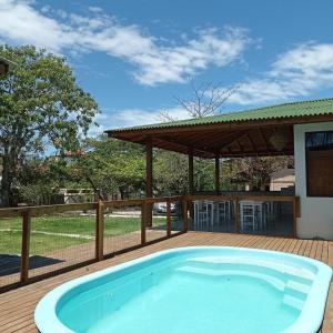 uma grande piscina num deque com um pavilhão em Pousada la Boheme Guarda do Embaú - SC em Guarda do Embaú