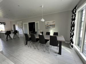 uma sala de jantar com uma mesa e cadeiras pretas em Ski Villa Serena em Pyhäjoki