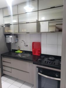 uma cozinha com armários brancos e uma caixa vermelha no balcão em Apt 2 QUARTOS, 2 WC, POINT DA JATIÚCA ACOMODA 9 em Maceió