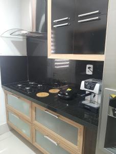 a kitchen with a black counter top with a stove at FlatStudio02 em condomínio residencial na Nova Betânia in Mossoró