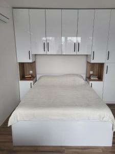 a bed in a room with white cabinets at OPTIMUM 1 apartment - One bedroom - in core city center in Zenica