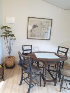 een eettafel met stoelen en een foto aan de muur bij Iryang Stay in Goseong