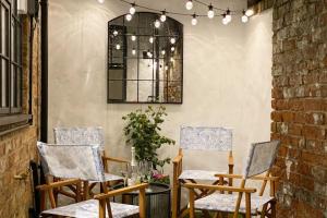 a patio with three chairs and a table and a window at Menagerie House Luxury City Cottage, Walk Score 98 in York