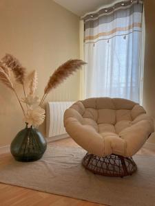 uma sala de estar com um sofá e um vaso com flores em Appart Cosy 2 chambres em Bruz