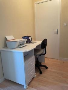un bureau avec un bureau, un ordinateur portable et une chaise dans l'établissement Appart Cosy 2 chambres, à Bruz