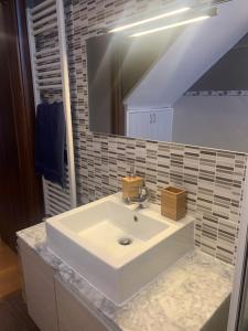 uma casa de banho com um lavatório branco e um espelho. em O' Sapunariello-Casa Vacanze em Nápoles