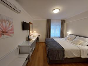 a bedroom with a bed and a desk with a computer at Sport Manca Garni Hotel in Radovljica