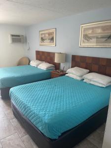 2 łóżka w pokoju hotelowym z niebieską pościelą w obiekcie The Atlantic w mieście Myrtle Beach