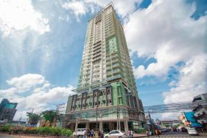 a tall building on a city street with a cloudy sky at 2313 Sun Vida Tower in Cebu City