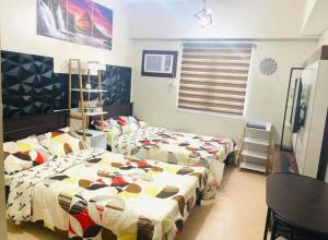 a bedroom with two beds and a table and a desk at 2313 Sun Vida Tower in Cebu City
