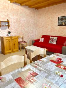 ein Wohnzimmer mit einem roten Sofa und Tischen in der Unterkunft Appartamento 2 Baita Sosio Livigno in Livigno