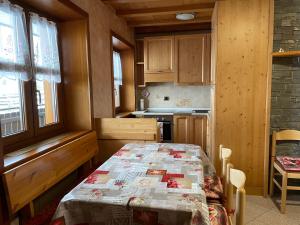 eine Küche mit einem Tisch und einer Decke darauf in der Unterkunft Appartamento 2 Baita Sosio Livigno in Livigno