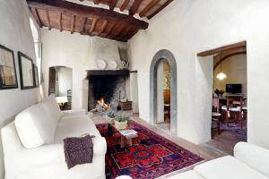 a living room with a white couch and a fireplace at Castello di Bibbione in San Casciano in Val di Pesa