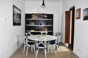 een eetkamer met een witte tafel en stoelen bij Le Radici Home in LʼAquila