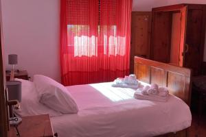 Casa vacanze Fregè في Castione Andevenno: غرفة نوم بسرير ابيض عليها مناشف