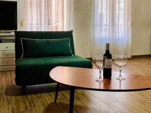 a living room with a green couch and two wine glasses at Seaview Heaven - Otium Apartments in Santa Pola