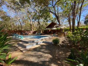 a swimming pool in a yard with chairs and trees at CASA NATURAL in Brasilito