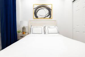69-2D Stylish Lower East Side 1BR Apt BRAND NEW في نيويورك: سرير أبيض مع وسادتين في غرفة النوم