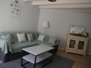sala de estar con sofá verde y mesa en Chambre et salon sur la Loire à vélo, en Les Ponts-de-Cé