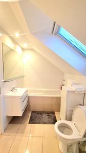 a bathroom with a white toilet and a sink at Modern & cozy house with 3 bed rooms and garden in Prievoz