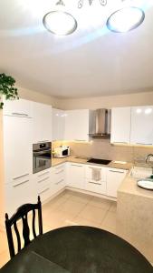 a kitchen with white cabinets and a chair in it at Modern & cozy house with 3 bed rooms and garden in Prievoz