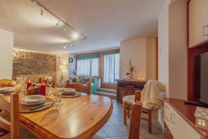 cocina y sala de estar con mesa de comedor de madera en LA LEITERY DU MONT BLANC 1 - Comfort e Posto auto - COUR 0140, en Courmayeur