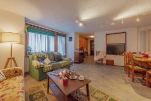 una sala de estar con un sofá y una mesa en LA LEITERY DU MONT BLANC 1 - Comfort e Posto auto - COUR 0140, en Courmayeur