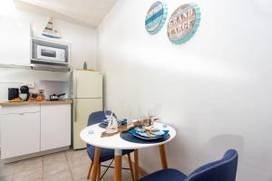eine Küche mit einem Tisch und Stühlen sowie einem Kühlschrank in der Unterkunft Le petit marin des salines à 0 metre de la plage in Montjoly